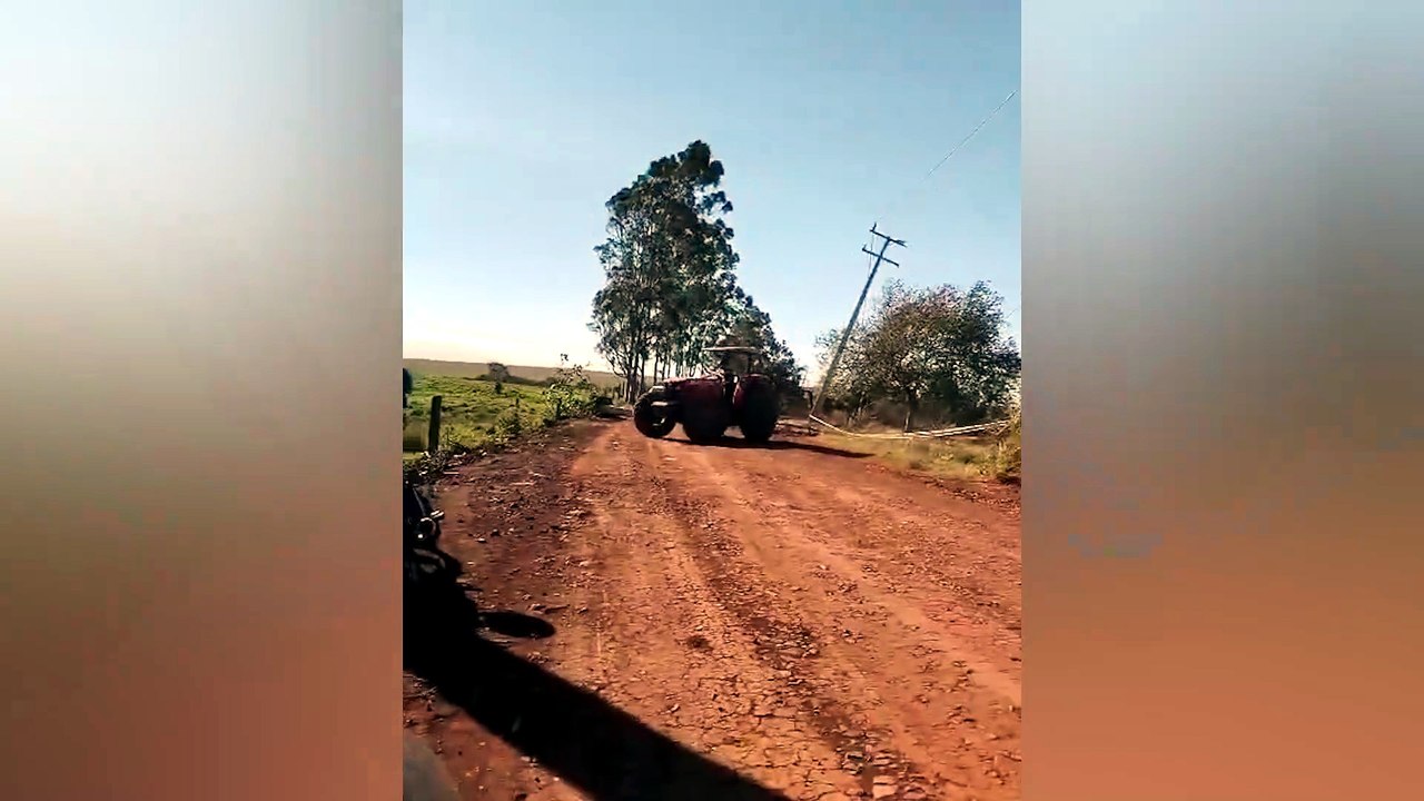 Moradores usam trator para retirar poste caído que interditava estrada em Juvinópolis