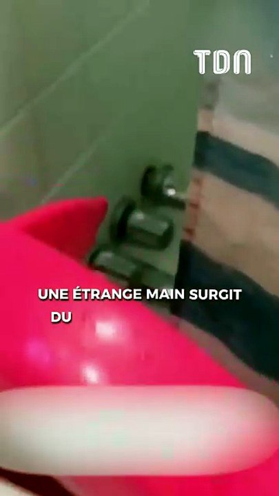 Une étrange main surgit du mur de sa salle de bain