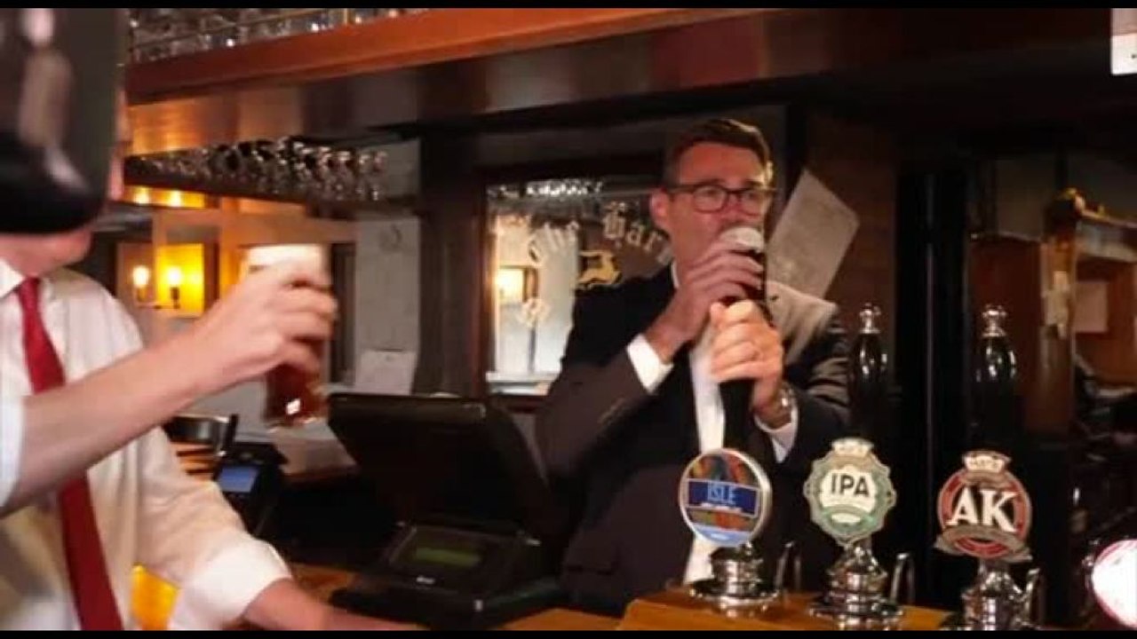 Andy Burnham festeggia il taglio delle tasse al pub con birra in mano