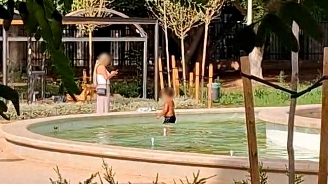 Piscina urbana contra el calor en Palma: una madre equipa a su hijo con bañador y lo mete a nadar en una fuente