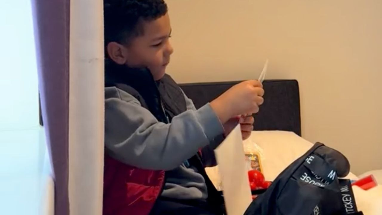 Boy Opens A Bag Of Gifts Before Learning About Disneyland