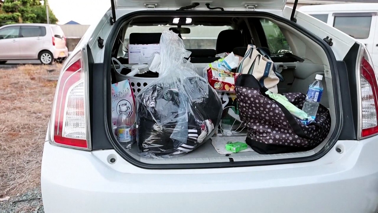 Days after Japan's quake, a family shelters in their car in sweltering heat