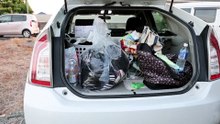 Days after Japan's quake, a family shelters in their car in sweltering heat