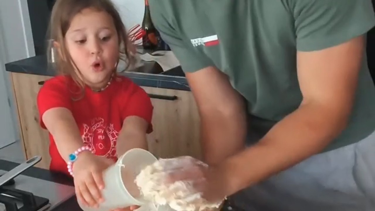 The little girl reacts with pure joy while helping make fresh pasta at home