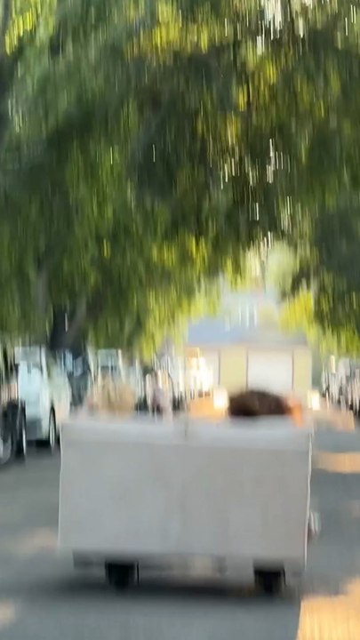 Women transport full couch using e-scooters in...