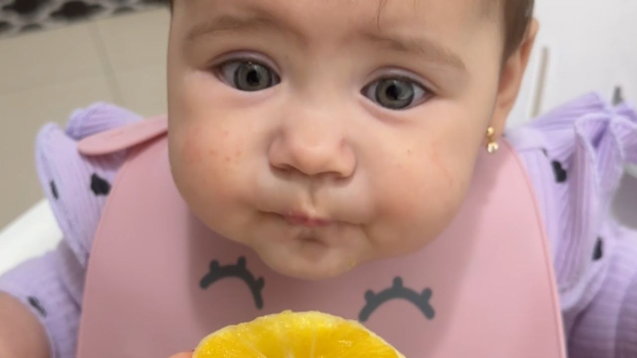 Charming infant experiences orange for the first time
