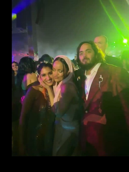 Rihanna poses with bride and groom following in...