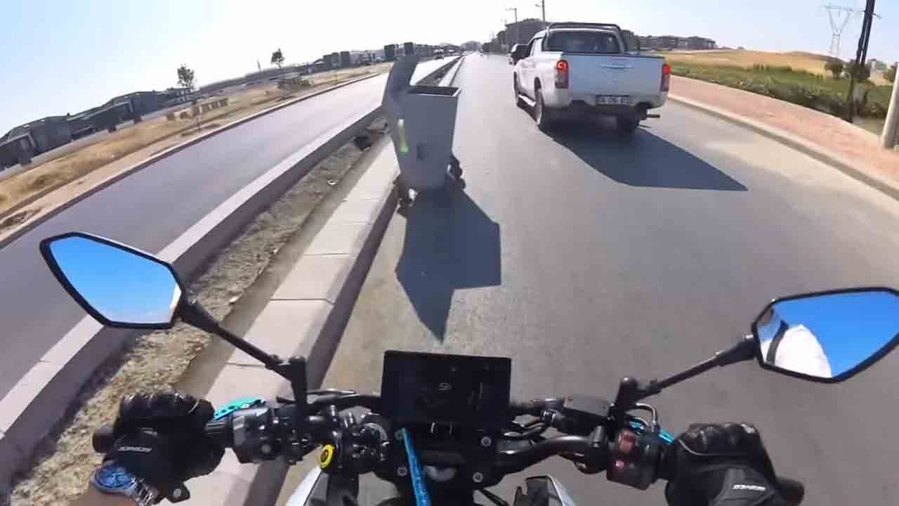 Un motard percute un conteneur à déchets lors d’un dépassement, la scène filmée par une caméra