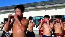 The children at the martial arts school are in class, doing their drills