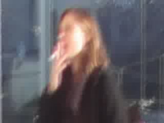 Elodie Varlet fume une cigarette devant les studios de PBLV