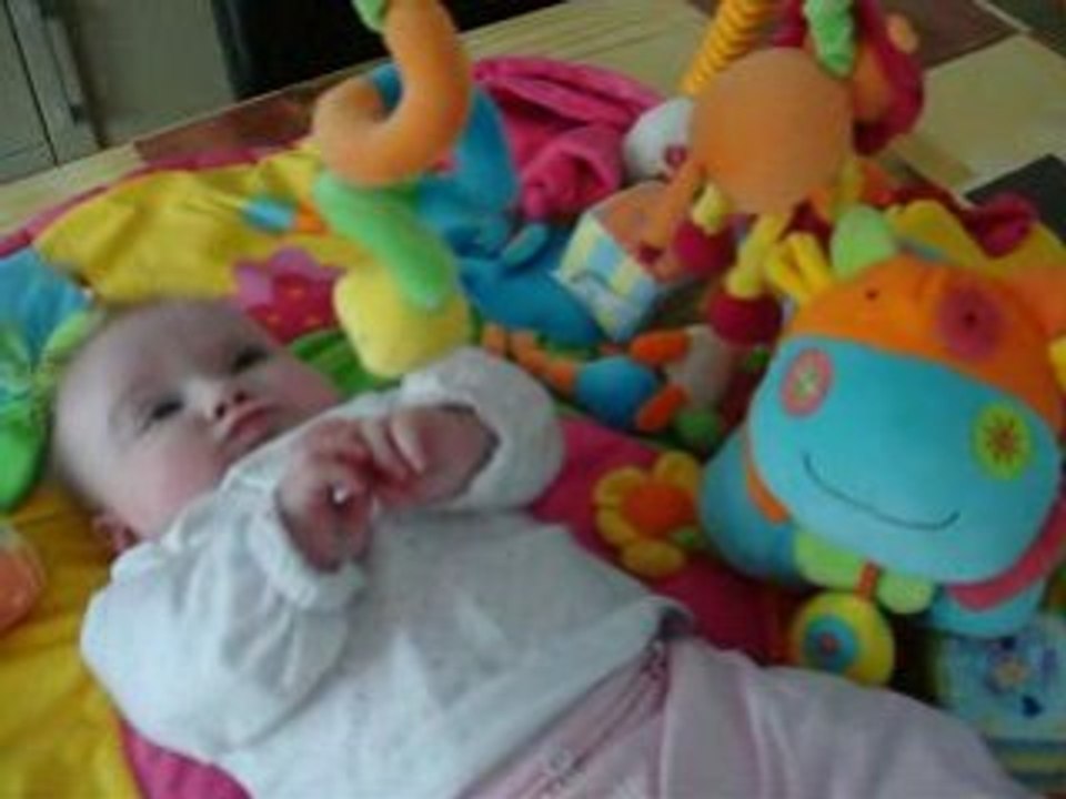 Manon avec sa vache sur son tapis d'éveil