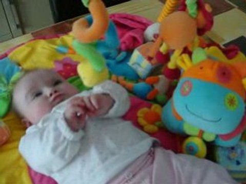 Manon avec sa vache sur son tapis d'éveil