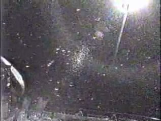 A  flat, rotating UFO foats by NASA shuttle