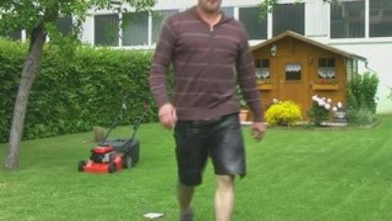 Lutz beim Rasen mähen in der Lederhose