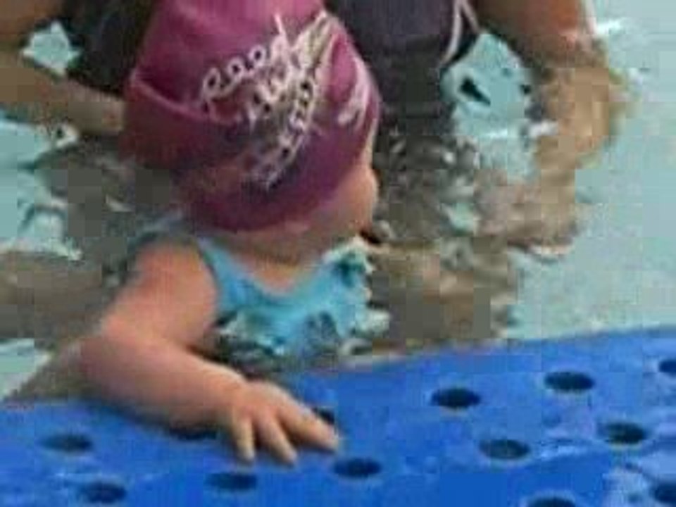 Inès se tient toute seule au bord de la piscine!